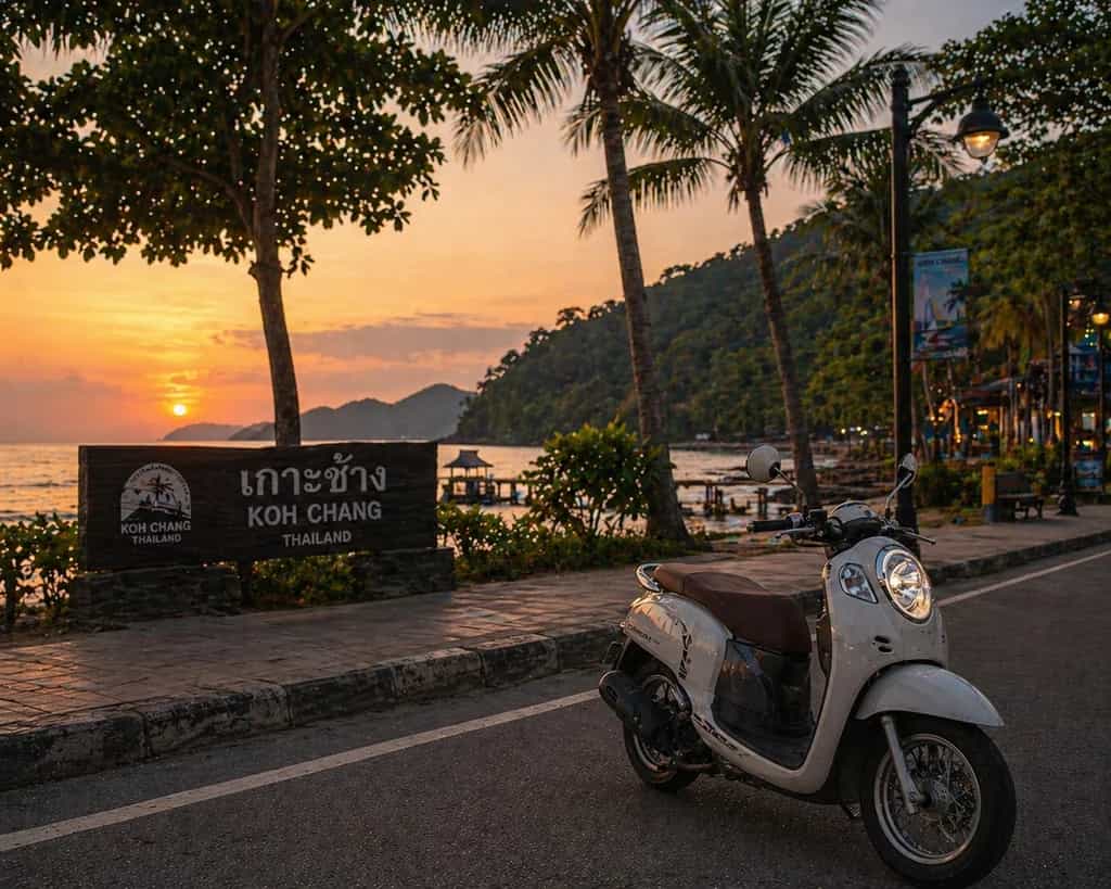 Honda Scoopy scooter at the Koh Chang waterfront welcome sign at sunset in Thailand: Byklo scooter rental