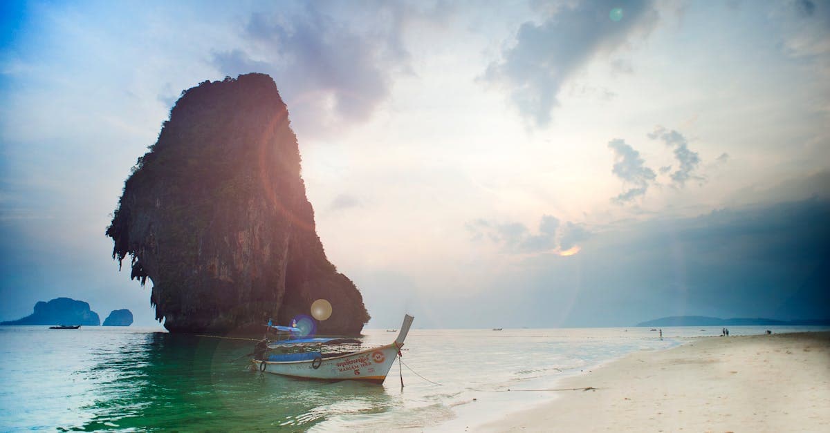 Tranquil seascape with boat and cliff at sunset, Ao Nang, Krabi, Thailand.