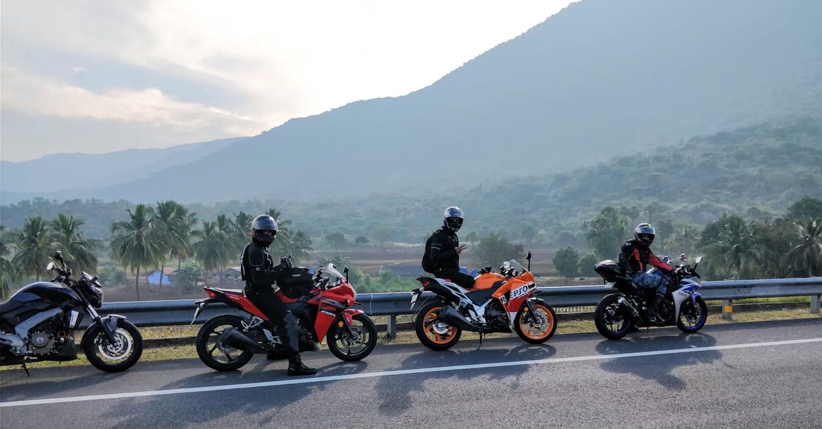 Three motorcyclists on a scenic mountain road with lush greenery in the background, enjoying a ride.
