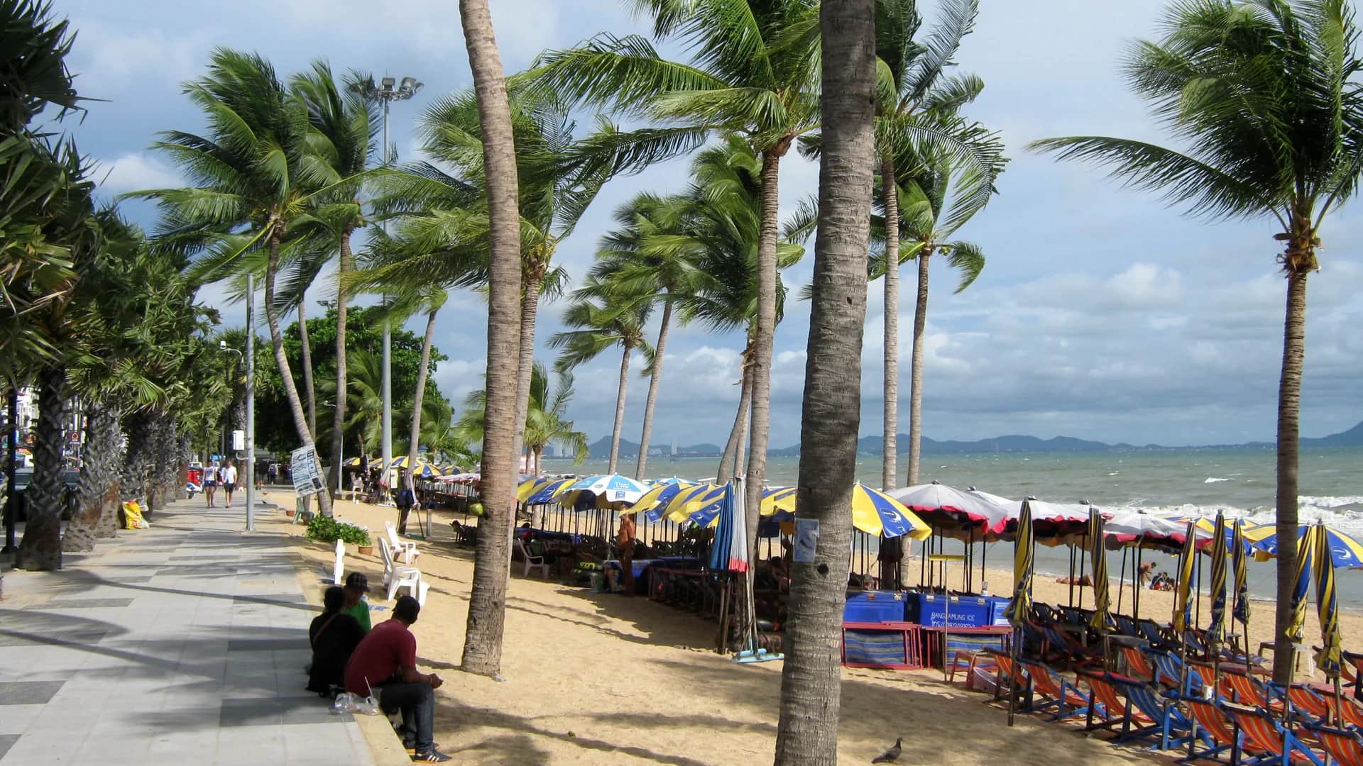 中天，泰国的Jomtien Beach Road promenade with palm-lined deck-chair strip