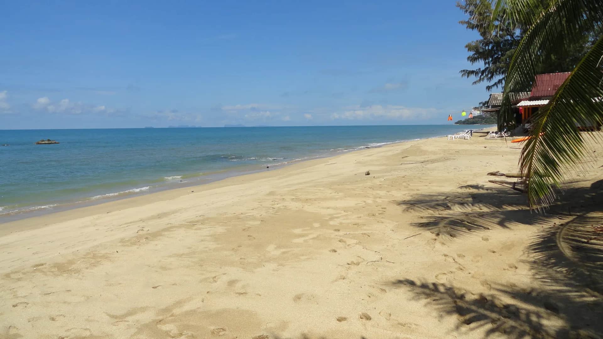 Klong Nin Beach umbrella-tree shade strip in Koh Lanta, Thailand